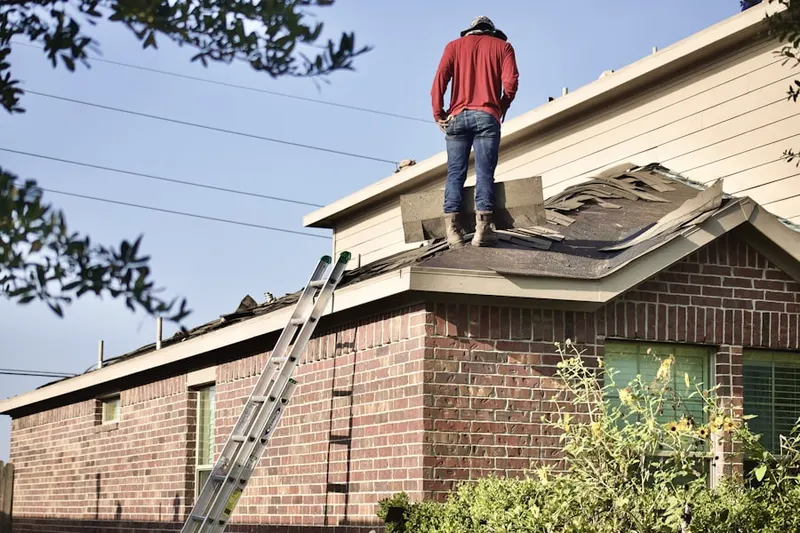 Professional roofer working on a residential roof in West Pleasant Valley